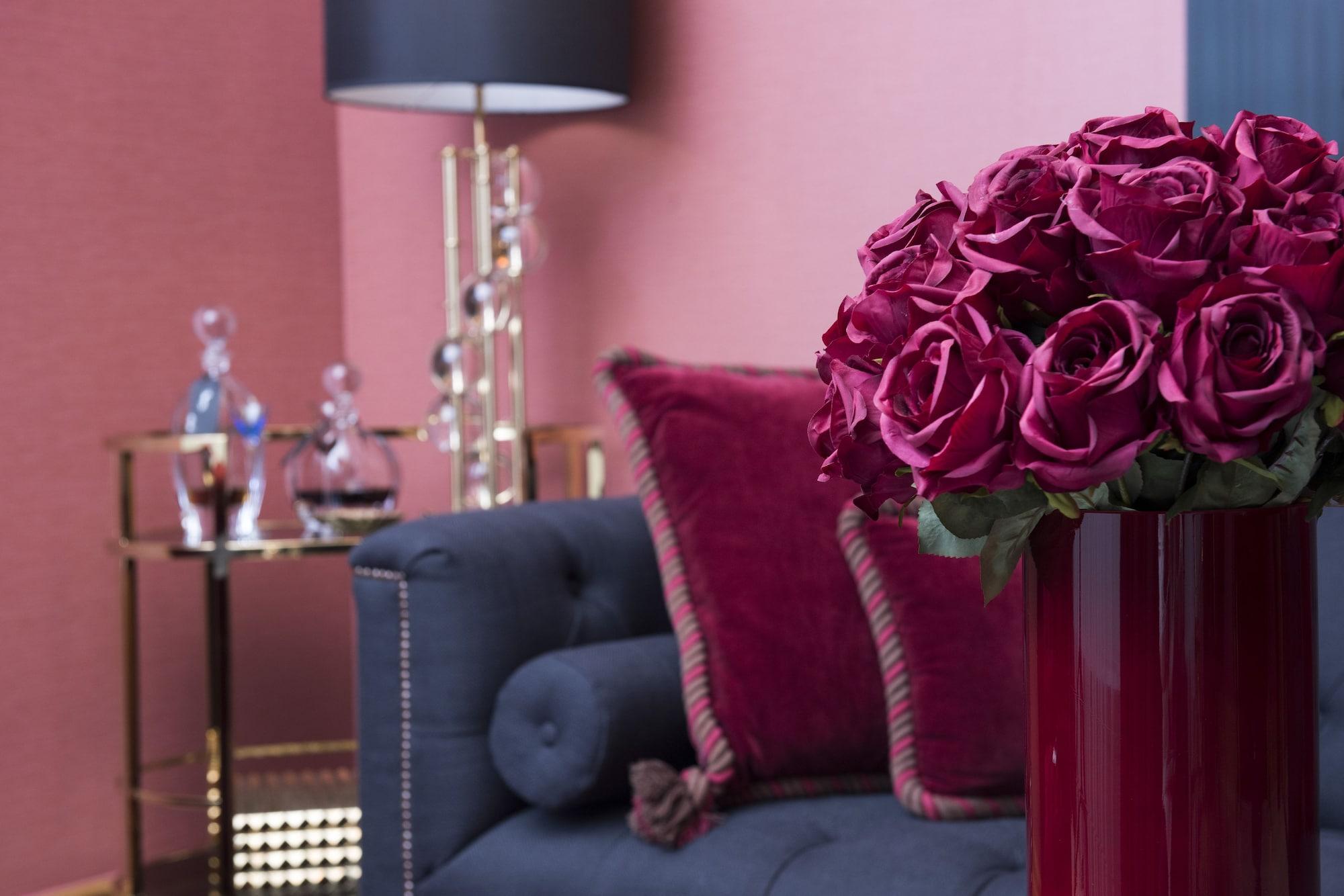 Hotel Palace Берлин Екстериор снимка A living room with a dark blue sofa and a red vase